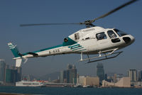B-KHS @ HKG - Heliservices of Hong Kong after lift-off at Queen Victoria Business District Heliport. Background Kowloon with Star Ferry Terminal