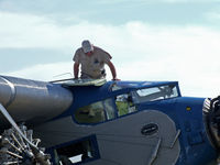 N8407 @ OSH - A crewman climbs out to check the tanks