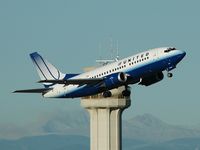 N921UA @ YYC - departing 34 with tower and rockies in back - by Bill Knight