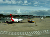 VH-QOE @ YBBN - De Havilland Canada DHC-8-402Q Dash 8 VH-QOE finishes refuelling as VH-QOB taxis in.