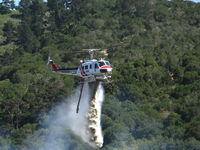 N498DF - CDF Bell UH-1H Helitak 406 dropping on fire off of State Hwy 68 ~ 4 miles NE of Monterey, CA - by Steve Nation