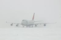 N673US @ CID - NWA9840  taxiing eastbound on Alpha to pick up the U of I football team.  Snowing with 25-30kt wind blowing snow. - by Glenn E. Chatfield
