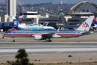N645AA @ LAX - American Airlines N645AA (FLT AAL25) holding short of RWY 25R after arrival on RWY 25L from Boston Logan Int'l (KBOS). In the background, the Alaska Airlines Spirit of Seattle taxis to RWY 25R for departure.