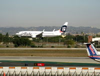 N559AS @ LAX - Alaska 2006 Boeing 737-890 landing on RW 24R w/red lei necklace (new Hawai'i service) - by Steve Nation