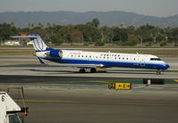 N744SK @ LAX - United Express 2005 Bombardier CL-600-2C10 in latest colors (small Sky West Airlines titles) taxiing to RW 24L - by Steve Nation