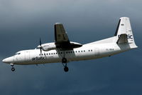 YL-BAA @ ESSA - A white Air Baltic Fokker 50 in front of a dark cloud about to land at Stockholm Arlanda. Note the bad paintwork. - by Henk van Capelle