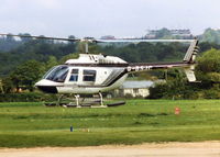 G-BSJC @ EGHR - JETC HELICOPTERS JET RANGER WITH GOODWOOD RACE COURSE GRANDSTAND IN THE DISTANCE, 1990. LATER REG. G-BVRC, G-SPYI, TO SEYCHELLES JUNE 2006  - by BIKE PILOT