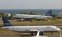 N506JB @ TNCM - Jet Blue N506JB Landing at TNCM while Jet BLue N709JB hold at THE holding point ALpha for take off