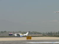 N70987 @ POC - Standing by at runway 26L for landing aircraft. Note large photo opening at rear of the plane with somebody setting there - by Helicopterfriend