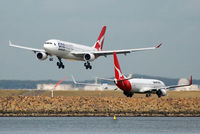 VH-EBL @ YSSY - VH-EBL is about to touch down, while VH-VYL is taxiing for take-off - by Micha Lueck