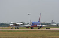 N101VK @ KAUS - Cessna lands with a SWA in the background. - by Darryl Roach