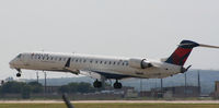 N605LR @ KAUS - DAL CRJ touches down 17L. - by Darryl Roach