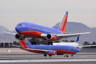 N350SW @ LAS - Southwest Airlines N350SW landing RWY 25L, while Southwest Airlines N243WN holds short, and Delta Air Lines N840MH holds in position on RWY 25R.