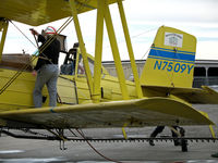 N7509Y - Pilot of Tolle's Flying Service (Robbins, CA) 1992 G-164B-20T cleaning windshield of N7509Y between flights at owner's private airstrip near junction of State Hwy 113 and Reclamation Road - applying liquid fertilizer to wheat this day with spray bars