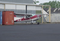 ZK-CAV @ NZAR - Trying to hide behind the containers - always there - not yet seen fly. - by magnaman