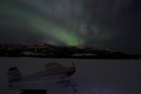 C-GINC @ CEZ5 - On skis on Lake Schwatka, with the aurora borealis (Northern Lights) overhead. - by Murray Lundberg