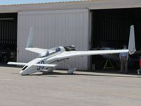 N186JH @ CNO - Kneeling outside a hanger with engine cowling off - by Helicopterfriend