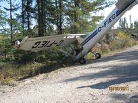 C-FIEG - On way to Yellowknife from Montreal, Pilot had enging trouble.  Tried to land on this road, but clipped a tree.  No Injuries. - by Dennis Hallett