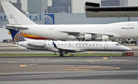 N11189 @ KEWR - A United Express regional jet appears to be overshadowed by the jumbo freighters in the background. - by Daniel L. Berek