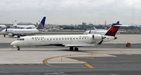 N653CA @ KEWR - A Delta Connection CRJ taxies past chaos on Newark Liberty International's taxiways and runways caused by delays because of severe thunderstorms. - by Daniel L. Berek