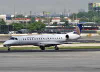N15986 @ KEWR - The sun shines on a United Express ERJ after a rainstorm at Newark International. - by Daniel L. Berek