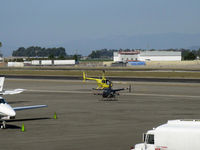 N442EK @ OXR - 2002 Robinson R44 CLIPPER, Lycoming O-540-F1B5 260 Hp derated to 225 hp for takeoff, 205 Hp continuous. Pop-out floats, the yellow chopper arriving to the ramp-hover to landing - by Doug Robertson