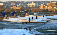 N336NG @ KEWR - A United Express DHC Dash-8 heads up a gaggle of shivering turboprops at a remote corner of EWR on a cold January evening. - by Daniel L. Berek