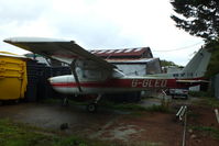 G-GLED @ EGTR - parked in the gap between two hangars - by Chris Hall