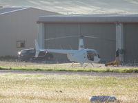 ZK-INC @ NZNE - wider angle view in front of the rows of private hangars. Looked like at least three other helicopters in same hangar including ZK-HPT - by magnaman