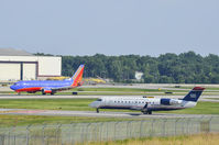 N223JS @ KCLT - US Airways Bombardier CL-600 waits for a Southwest Airlines 737-3H4 (N618WN) to pass at Charlotte International Airport on June 22, 2014.