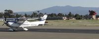 N2214L @ KRHV - A local 2005 Cessna 182T sitting on the transient ramp after dropping off some passengers. Cessna N54102 and the Reid Hillview Tower both in the background. - by Chris Leipelt
