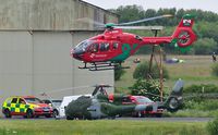 G-WASN @ EGFH - Wales Air Ambulance helicopter (Helimed 57) departing base. Parked up is Army Air Corps Westland Gazelle AH.1 helicopter ZB665. - by Roger Winser