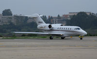 N998QS @ KSBA - NetJets 2002 Cessna 750 taxiing with UCSB campus in background @ Santa Barbara Municipal Airport, CA - by Steve Nation