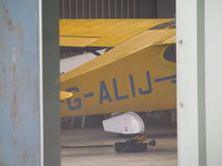 G-ALIJ @ EGHP - Glimpse of old cub through hangar door - by magnaman
