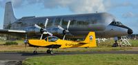 G-UPRT @ EGHH - Taxiing past a decaying Guppy - by John Coates