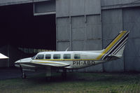 PH-ABD @ EHRD - Piper PA-31-350 Navajo Chieftain of Rijnmond Air Services behind a hangar at Rotterdam Zestienhoven airport, the Netherlands, 1983