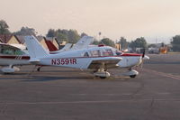 N3591R @ SZP - 1970 Piper PA-28-180 CHEROKEE, Lycoming O&VO-360 180 Hp, on Transient ramp during the Thomas fire, note fire fighting helicopter in distance on Rwy 22 and smoky sky. - by Doug Robertson