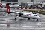 VH-QOD @ YSSY - TAXI TO A WET 16R - by Bill Mallinson