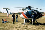 VH-JBE @ YCOM - Hughes 369E VH-JBE Cn 0148E being inspected  on static display at Cooma Airport YCOM, during the 'Snow Opening' Airshow on 11May1986. The helo was previously USA Registered as N5229J, and was being operated for U.A.A. Films Limited in Sydney in Nov 1985. - by Walnaus47