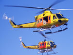 VH-NSO @ YSCB - Two NSCA Helicopters (in High-Vis Yellow livery) hovering at the 1988 (Bi-Centennial) Canberra Air Pageant on 13Mar1988.  Bell 412 VH-NSO Cn 33089 Code 11, and Bell 205 VH-NSM Cn 30002 Code 05 is equipped with a water tank and filler hose. - by Walnaus47