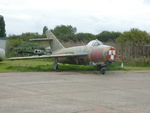 G-MIGG @ EGSX - 1958 MiG17F stored at North Weald outside Hangar 4 with its nose covered in legal demands for the owner to collect and pay. - by Chris Holtby