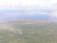  - Unused WW2 airfied on northern end of Tinian, Saipan in upper right of photo - by John J. Boling