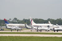  - Delta aircraft arrives in background of a big group of parked planes for the race - by Florida Metal
