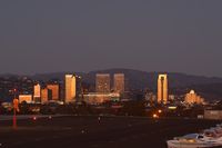  - View looking northeast toward the approach end of RWY 21, with the buildings of Century City beautifully lit from the orange sky after sunset. - by Dean Heald