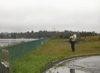  - Japanese Bus Tour-Seaplane viewing and photography on a wet, but flyable day. Tourist getting one last shot. - by Doug Robertson