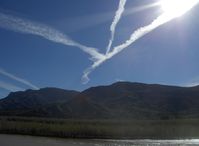  - Three jet contrails converging over Fillmore VORTAC FIM near SZP, South Mountain in background. Santa Clara River flowing from snowmelt and rain at base of photo. - by Doug Robertson