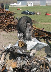  - The remains of a Piper PA-28 after a hangar fire.  Note the fiberglass cloth from the nose wheelpant survived, but the resin has melted away. - by Timothy Aanerud
