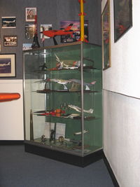  - Representative aircraft, targets & missile models in Point Mugu's history. My white Texas Instruments mounted on plaque HARM AGM-88A missile model donation-center top shelf - by Doug Robertson