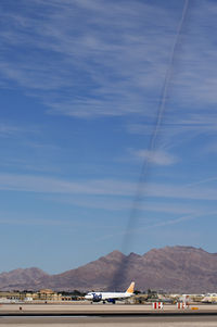  - I found this very bizarre: the sun was in the right position to cast a shadow of overhead contrails on the mountain in the background.  Ted Airlines N470UA awaiting take-off - by Brad Campbell