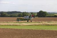  - With the runway specially extended, Spitfire G-CTIX lifts off the runway upslope during the VE Day celebrations in 2005. - by Malcolm Clarke